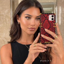 Load image into Gallery viewer, Woman holding a red and black snakeskin phone case by PURITY
