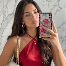 Load image into Gallery viewer, Woman holding a luxury iPhone case with floral design against a marble background
