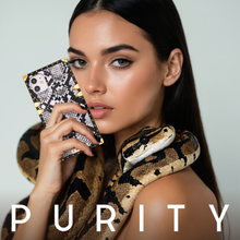Load image into Gallery viewer, Woman holding a black and white snake skin phone case by PURITY.
