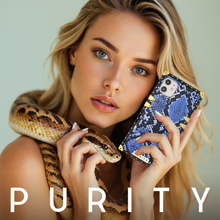 Load image into Gallery viewer, Woman holding a blue snake skin phone case by PURITY.
