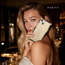 Load image into Gallery viewer, Woman holding a luxury golden iPhone case with woven design by PURITY.
