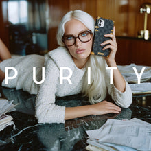 Load image into Gallery viewer, Woman holding a phone with a grey checkered square case, sitting at a table in an office.
